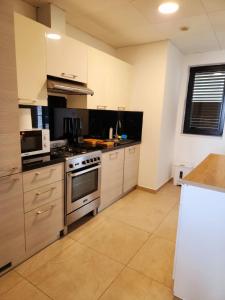 a large kitchen with a stove and a microwave at Premium 2 Bedroom Apartment Near Airport in Muscat +16 photos