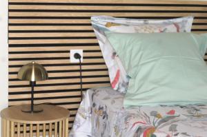 a bed with a pillow and a lamp on a table at Chambre indépendante, sdb privée in Saulcet