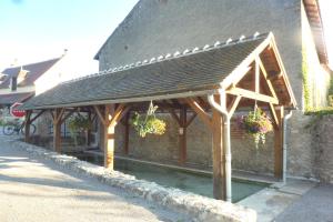 a wooden pavilion with potted plants on a building at Chambre indépendante, sdb privée in Saulcet
