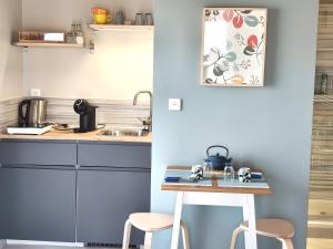 a small kitchen with a table and two stools at Chambre indépendante, sdb privée in Saulcet +6 photos