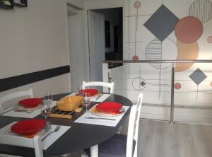 a dining room with a black table and white chairs at Le Gîte Du Vigneron in Saulcet +13 photos