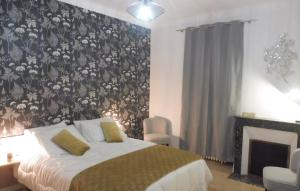 a bedroom with a bed with a floral wallpaper at Le Gîte Du Vigneron in Saulcet