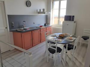 a kitchen with a table with chairs and a sink at Le Gîte Du Vigneron in Saulcet