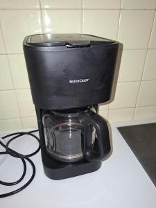 a black coffee maker sitting on top of a counter at La maison de Zélia in Boissières