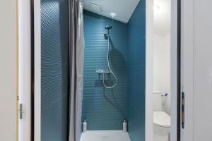 a bathroom with a shower with blue walls at Fenêtre sur le Neron in Quaix +14 photos