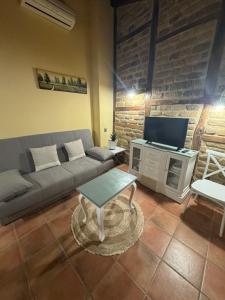 a living room with a couch and a tv at APARTAMENTOS La Colmena APT- 2 - AT-CC-00248 in Gata