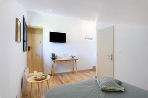 a bedroom with a bed and a tv on the wall at Fenêtre sur le Neron in Quaix
