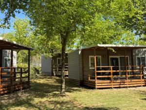 a couple of cottages with trees in the yard at New Campsite in Camping Ca' Savio in Cavallino-Treporti