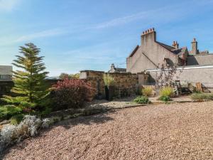 a house with a gravel driveway in front of it at Crown Cottage in Dunfermline