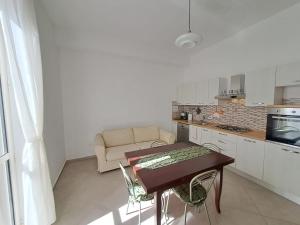 a small kitchen with a table and a couch at Medoro Gioiosa 2 in Gioiosa Marea