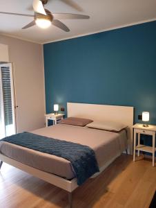 a bedroom with a bed with a blue wall at Punta sul Garda in Torri del Benaco