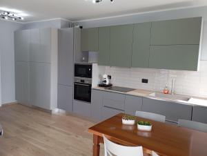a kitchen with white cabinets and a wooden table at Punta sul Garda in Torri del Benaco +18 photos
