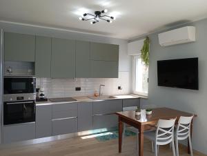 a kitchen with white cabinets and a wooden table at Punta sul Garda in Torri del Benaco