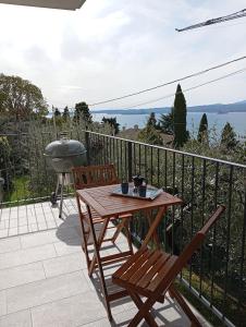 a table and chairs on a balcony with a grill at Punta sul Garda in Torri del Benaco