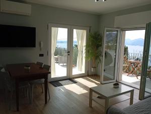 a living room with a table and a dining room with a view at Punta sul Garda in Torri del Benaco