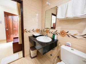 a bathroom with a sink and a mirror and a toilet at Cửu Long Beach Phú Quốc in Phú Quốc +40 photos