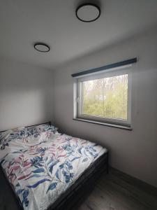 a bedroom with a bed and a window at Apartament Skorochów Jezioro in Skorochow