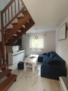 a living room with a blue couch and a table at Apartament Skorochów Jezioro in Skorochow