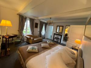 a bedroom with a large bed and a desk at Château du Romerel - Baie de Somme in Saint-Valéry-sur-Somme +66 photos