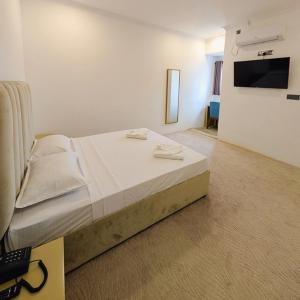 a bedroom with a bed with two towels on it at Kings hotel in Colombo +30 photos