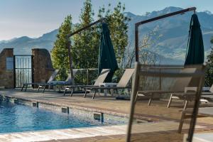 a swimming pool with lounge chairs and umbrellas at La Cabaña de La Nina in Beceña