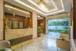 a lobby with a reception desk and a large window at Tripli Hotels Shourya Residency in Udaipur +76 photos