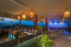 a restaurant with a bar and tables and lights at Tripli Hotels Shourya Residency in Udaipur