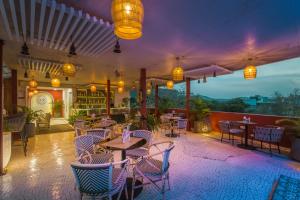 a restaurant with tables and chairs on a patio at Tripli Hotels Shourya Residency in Udaipur
