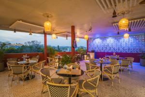 a restaurant with tables and chairs in a room at Tripli Hotels Shourya Residency in Udaipur