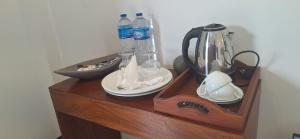 a wooden table with a blender and plates and water bottles at Royal Horizon in Nuwara Eliya