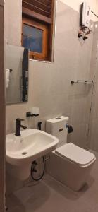 a bathroom with a white toilet and a sink at Royal Horizon in Nuwara Eliya