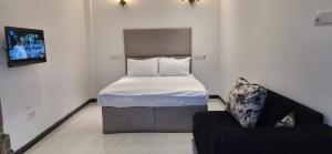 a small bedroom with a bed and a chair at Royal Horizon in Nuwara Eliya