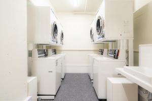 a white laundry room with white washers and dryers at Koraku Garden Hotel Tokyo in Tokyo