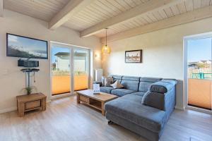 a living room with a couch and a tv at Ferienhaus Nordspitze in Dagebüll