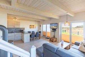 a living room and kitchen with a couch and a table at Ferienhaus Nordspitze in Dagebüll
