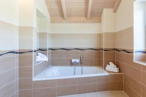 a bathroom with a bath tub in a room at Ferienhaus Nordspitze in Dagebüll +28 photos