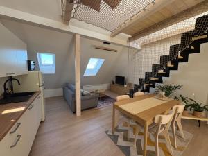 a kitchen and living room with a table and a staircase at Apartmán Ve Štítu in Lomnice nad Popelkou