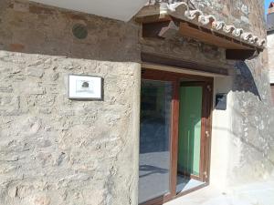 a stone building with a door and a sign on it at GuestHouse Tana del Riccio Todi in Todi