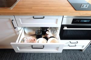 an open kitchen cabinet with white drawers at Zuidzuidwest in Zierikzee