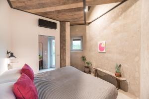 a bedroom with a bed with pink pillows at ROSTAGNI 1834 apt with pool in the Barolo region in Novello +35 photos