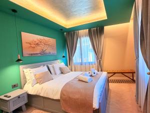 a bedroom with a large bed with green walls at DG kores in Metsovo