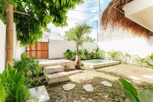 a courtyard with a pool and a palm tree at Villa Allegra in Mantaak