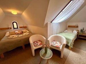 a bedroom with a bed and two chairs and a window at Rezidence - HAMR in Nové Hrady +14 photos