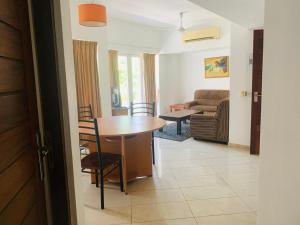 a living room with a table and a couch at Crystal Sand Mount Lavinia in Mount Lavinia