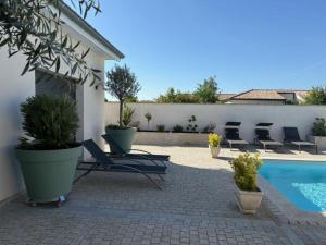 a patio with lounge chairs and a swimming pool at Les Crechois in Crêches-sur-Saône