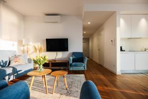 a living room with a couch and chairs and a tv at Jurata Residence in Jurata