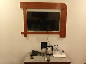 a television sitting on top of a table with a phone at White Turtle Resort in Morjim