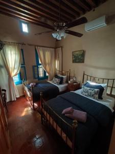 a bedroom with two beds and a ceiling fan at Boutique Hotel Beit el Nessim in El Mîna