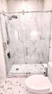 a white bathroom with a shower and a toilet at Bluehavenon30a-Between Rosemary & Alys Beach -Steps to Beach & Dining-Sleeps 3 in Rosemary Beach