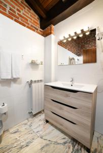 a bathroom with a sink and a mirror at Apartamentos La Cabaña del Cerro Alto in Beceña